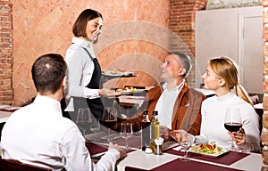 Waitress placing order in front of guests