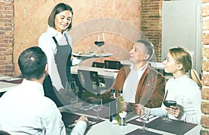 Waitress placing order in front of guests