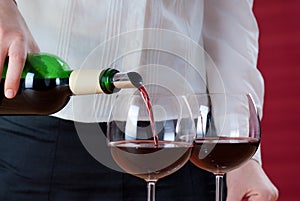 Waitress pouring red wine