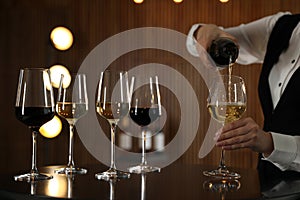 Waitress pouring wine into glass in restaurant,