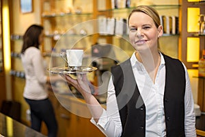 Waitress presenting cup of coffee or tea