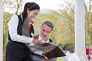Waitress presenting the menu to a guest in restaurant