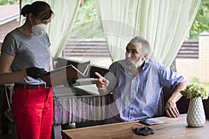 A waitress in a protective mask serves a client.