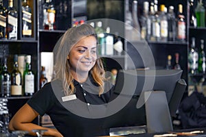 The waitress registrating order by cash register