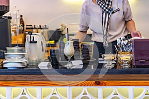 Waitress serving beverages at bar counter in Vietnamese coffee shop