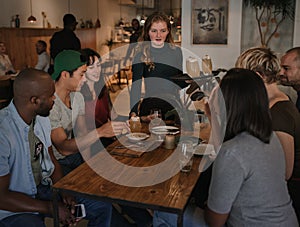 Waitress serving customers drinks in a bar at night