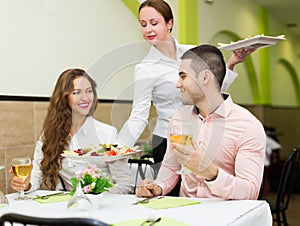 Waitress serving food to visitors
