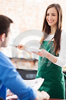 Waitress serving man at cafe