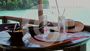 Waitress serving plates with food at a coastal cafe with a stunning sea view