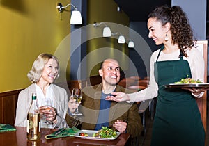 Waitress serving senior customers