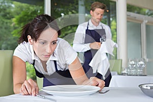 Waitress setting table in restaurant