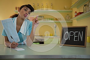 Waitress standing at counter in restaurant