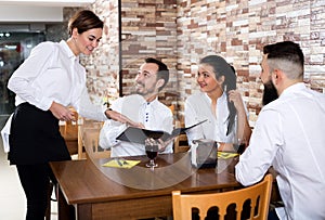 Waitress taking order at table of people