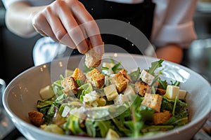 waitress topping a gourmet salad with croutons at a highend restaurant