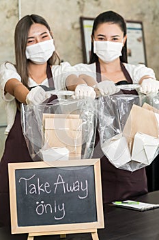 Waitress wear protective face mask hold food bag
