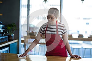 Waitress wiping table at counter
