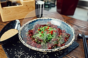 Wakame seaweed salad with walnut sauce and sesame seeds in a plate