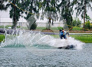 Wake boarding rider jumping trick with water splash.