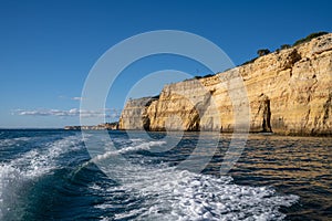 Wake of a high speed motorboat and view of ocean with cliffs