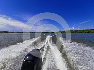 Wake leads water behind speeding boat