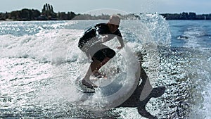 Wake surfer falling in water in slow motion. Man rotating on wake surf