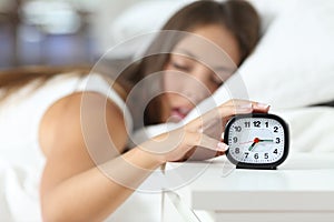 Wake up of an asleep girl stopping alarm clock