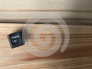 Wake up black button from computer keyboard put on natural rubber wood boards