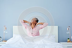 Wake up and feel alive. a happy young woman waking up in bed in the morning.