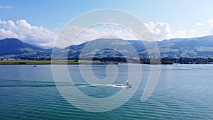 Wakeboard and Motorboat driving straight line on Lake Zurich, Switzerland. Watersport and drone aerial shot side view