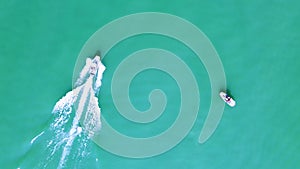 Wakeboard and Motorboat driving straight line on Lake Zurich, Switzerland. Watersport and drone aerial shot top down view