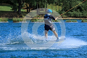 Wakeboard training with water splash and professional wakeboarder at a cable wakeboard park