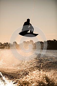 wakeboarder athlete man jumping high making tricks in the air