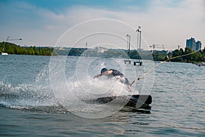 Wakeboarder cutting water with edge of board creating splashes