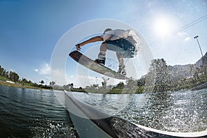 Wakeboarder jumps at ramp at wake park