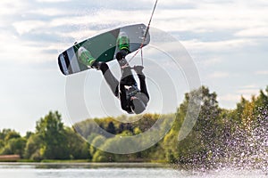Wakeboarder making tricks. Low angle shot of man wakeboarding on a lake.