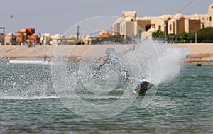 Wakeboarding sportsman jumping high in the cable park, water sports