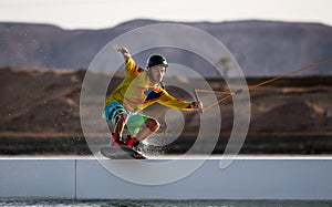 Wakeboarding sportsman on the slider in the cablepark