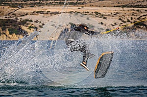 Wakeskater on a cable and doing a flip trick