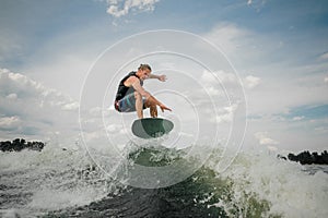 Wakesurf rider jumping on the waves of the river photo