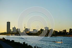 Wakesurfing on Danube river with sunrise background and view on Vienna.