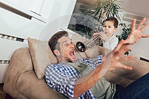 Son wakes up his dad by playing a trumpet photo