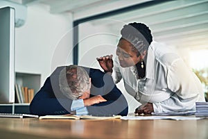 Wakey wakey. a businesswoman waking her colleague as he sleeps at his desk. photo