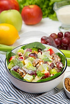 Waldorf salad with ingredients on a white wooden table. Selected focus.