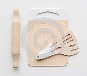 Waldorf toys on white background. Wooden rolling pin, spatulas and cutting board for play