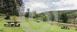 Wales countryside view of picnic benches in Hafren Forest park in summer