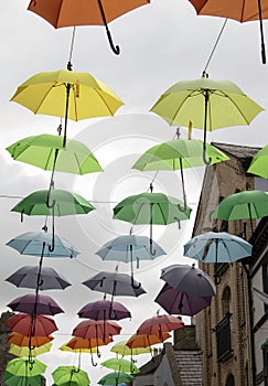 Wales, the city of Caernarfon. Coloured umbrellas. A narrow shopping street.