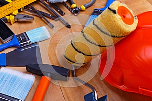 Wali on a helmet with scattered tools nearby for minor repairs on a wooden background