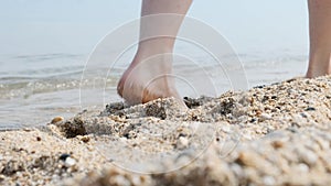 Walk along the beach. Legs close up. Slow motion