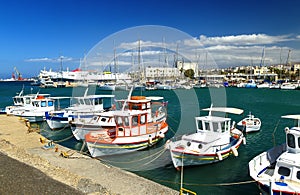 The walk along the harbor of Heraklion with ruins of Venetian era buildings and numerous yachts and boats in port, Crete