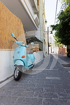 Walk around the old town. narrow street on which stands a blue scooter